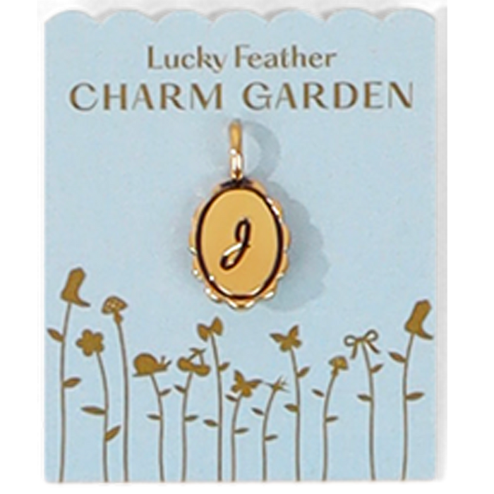 The image shows a gold-colored pendant with the letter 'J' on a light blue 'Lucky Feather CHARM GARDEN' card decorated with floral designs.