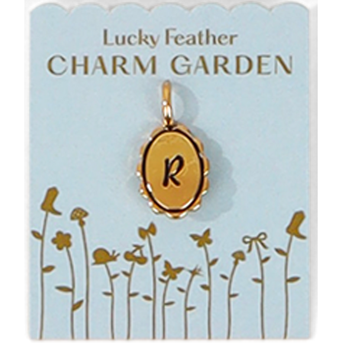 A gold charm with the letter R on a 'Lucky Feather Charm Garden' display card.