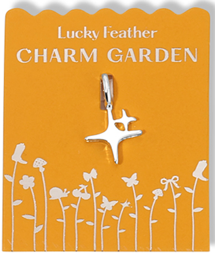 A Lucky Feather Charm Garden jewelry charm with an abstract star on a yellow card with flower and butterfly illustrations.