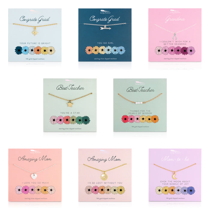 Arrangement of seven necklaces with charms on themed cards.