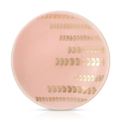 A pink plate is decorated with four horizontal lines of gold, leafy patterns.