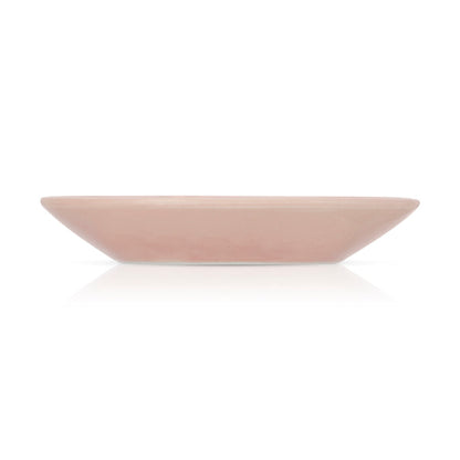 A light pink square ceramic plate is shown on a white surface.