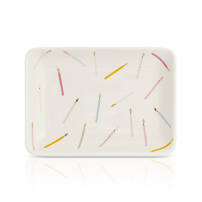 A rectangular dish is decorated with an assortment of birthday candles.