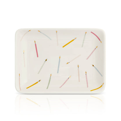 A rectangular dish is decorated with an assortment of birthday candles.
