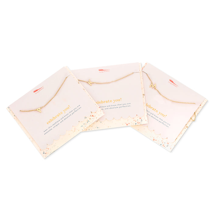 Three gold initial necklaces on gift cards are angled and displayed on a white background.