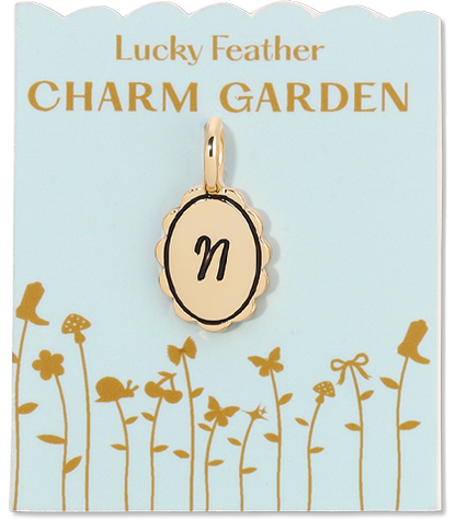 Gold charm with the letter 'n' on a card labeled 'Lucky Feather CHARM GARDEN'.