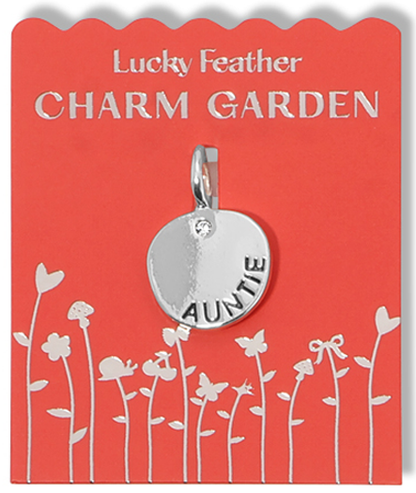 A silver 'Auntie' charm on a red 'Lucky Feather Charm Garden' display card with a silver floral design.