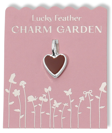 A brown heart charm hangs on a pink card with a silver floral design and the text 'Lucky Feather CHARM GARDEN'.