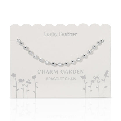 Silver beaded bracelet chain on a 'Lucky Feather Charm Garden' display card.