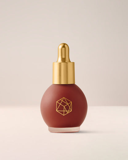 EM Cosmetics Color Drops Serum Blush in Forbidden Fruit, a vibrant poppy shade for a bold, buildable, dewy cheek color.