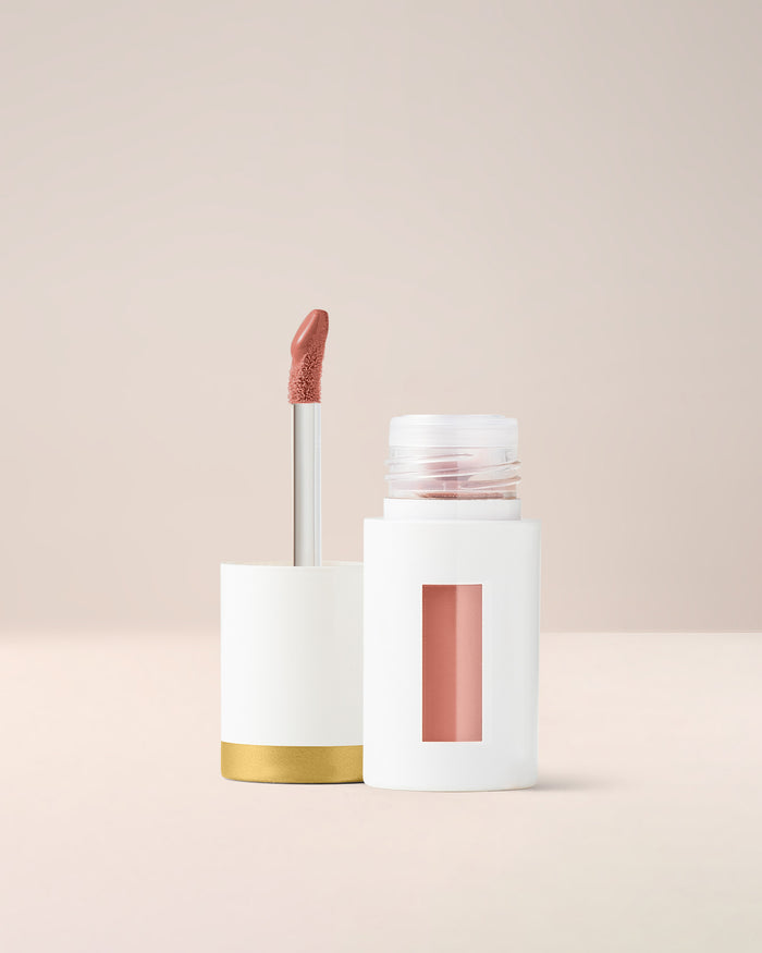EM Cosmetics Everglass Lip Dew in Lullaby, a peachy nude gloss that provides a comfortable, mirror-like shine.