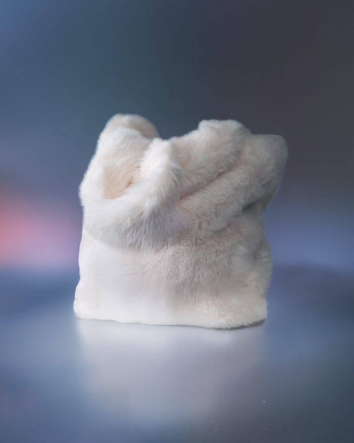 EM Cosmetics Snowball Bag, a white fuzzy round makeup bag with a plush texture.