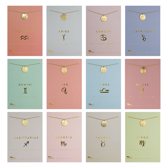 Twelve gold zodiac necklaces are displayed on individual cards.