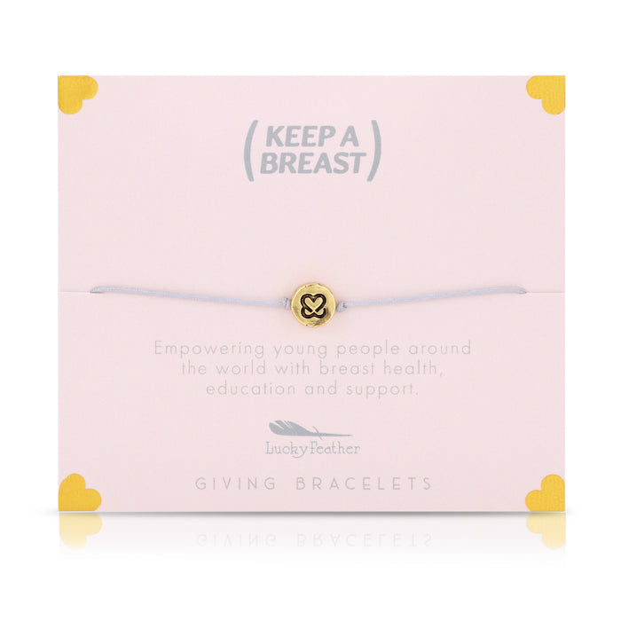 A bracelet with a gold charm sits on a pink card with the text 'Keep A Breast,' along with details on breast health education and support.