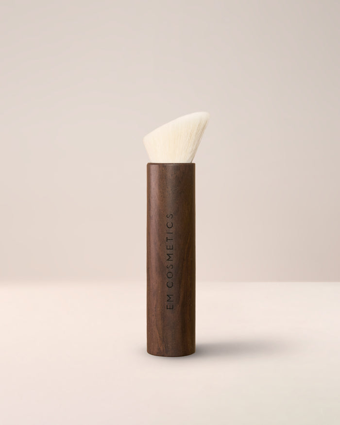 The EM Cosmetics Komorebi Face and Cheek Brush, featuring soft, angled bristles for effortless blush and bronzer blending.