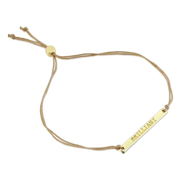 Adjustable cord bracelet with a gold bar pendant that reads 'BRILLIANT'.