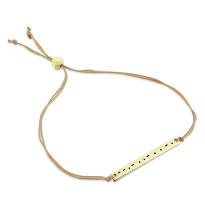 A tan cord bracelet features a gold-colored bar with a pattern of dots and dashes.