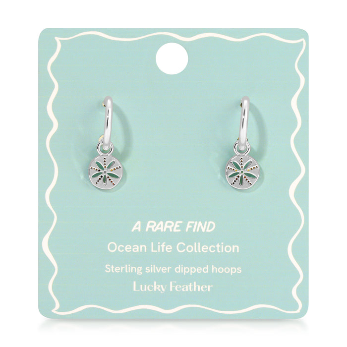Two silver hoop earrings with sand dollar charms are displayed on a blue-green product card.