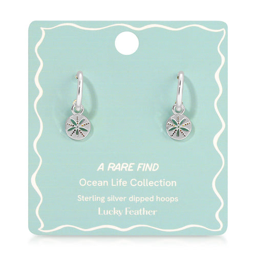Two silver hoop earrings with sand dollar charms are displayed on a blue-green product card.