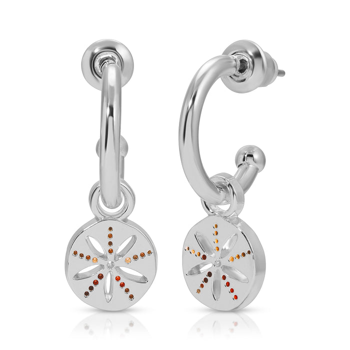 A pair of silver hoop earrings with flower-shaped pendants decorated with orange-toned stones are displayed on a white background.