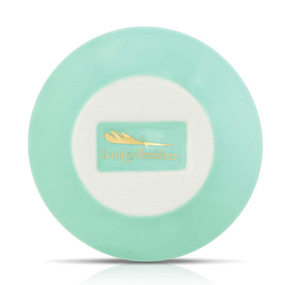 Overhead shot of a round, light turquoise dish with a white center displaying the 'Lucky Feather' logo.
