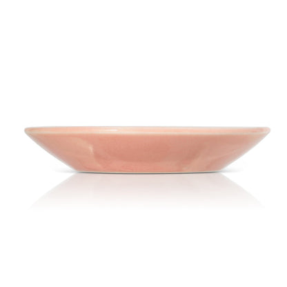 A pink ceramic dish is shown on a white background.